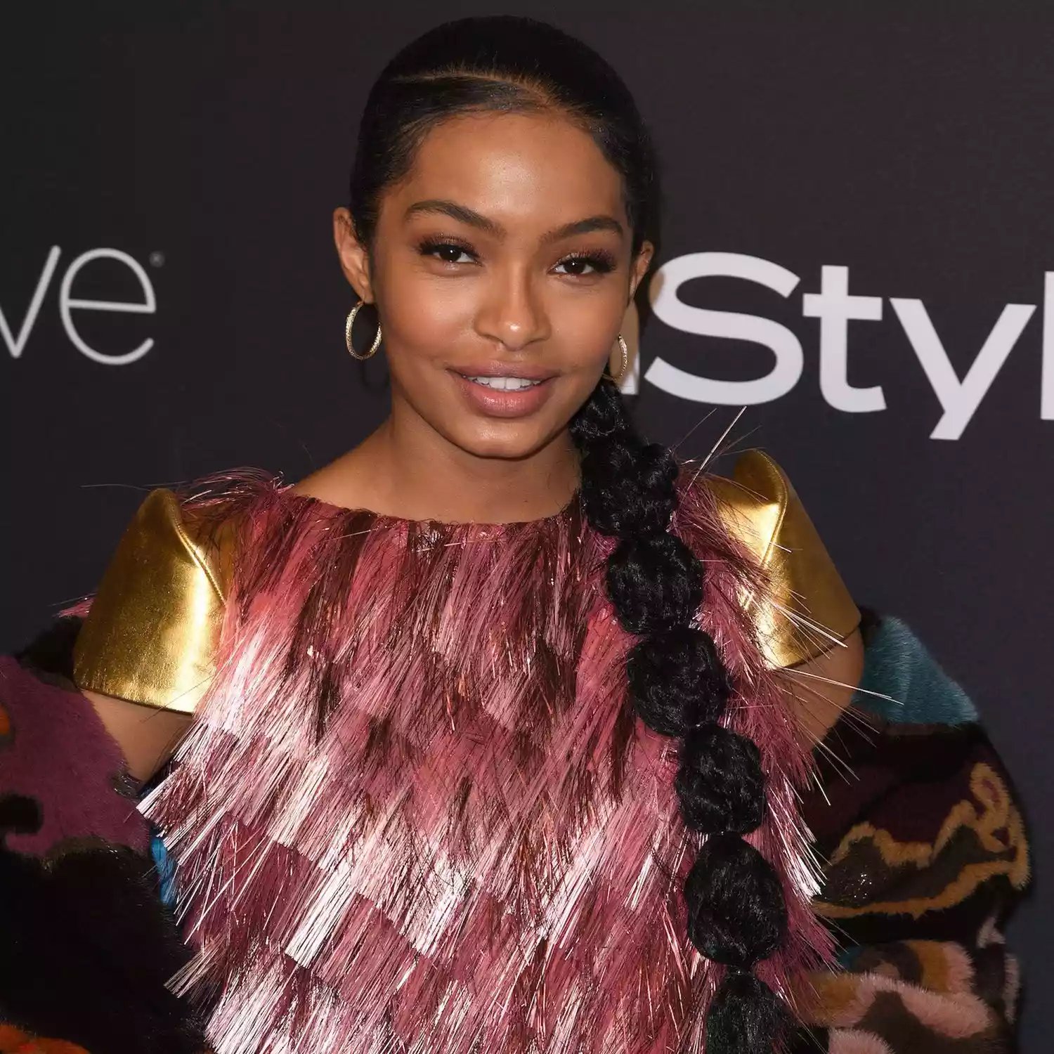 Yara Shahidi com uma parte lateral profunda e rabo de cavalo em forma de bolha